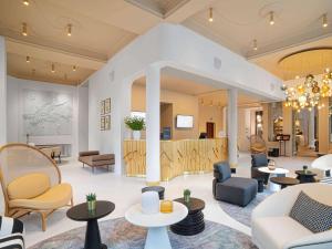 a lobby with couches and chairs and tables at Rezydent Sopot MGallery Hotel Collection in Sopot
