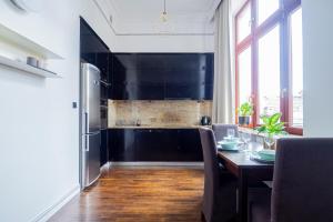uma cozinha com uma mesa e um frigorífico em AS HOME Apartamenty Rynek 50 R505 em Breslávia