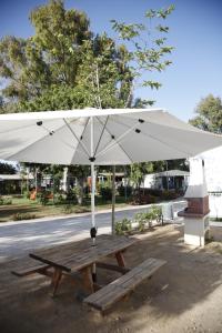 貝納哈拉菲的住宿－尼扎普拉亞野營山谷酒店，一张带白色雨伞的木制野餐桌