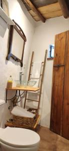a bathroom with a sink and a toilet and a table at La Morada de Higuera in Higuera de la Sierra