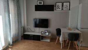 sala de estar con mesa y TV en la pared en Los Balcones de Laurel, en Logroño