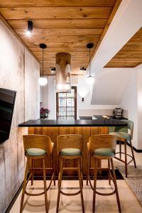 une cuisine avec un bar avec quatre chaises et un comptoir dans l'établissement Apartament Wenecja, à Zakopane