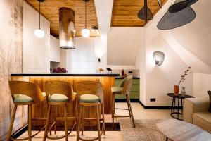 une cuisine avec un bar et des tabourets en bois dans l'établissement Apartament Wenecja, à Zakopane