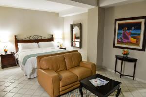 a hotel room with a bed and a couch at Plaza del General in Tegucigalpa