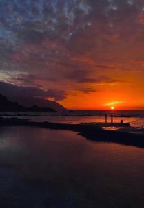 夫隆特拉的住宿－VV La Escondida，日落时分两人站在海滩上