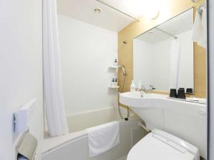 a white toilet sitting next to a sink in a bathroom at Smile Hotel Premium Hakodate Goryokaku in Hakodate