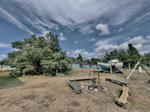 a playground with a boat and a fire pit at Camping Zvejnieksēta in Pāvilosta