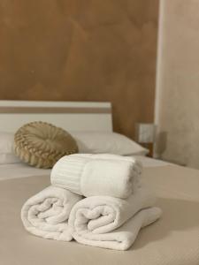 a stack of white towels sitting on a bed at Le Stanze della Braceria Calabrese in Scilla