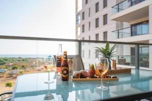 a glass table with two glasses and a bottle of wine at Achziv Beach Life with Stunning Sea Views by Sea N' Rent in Nahariyya