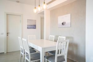 a white dining room with a white table and chairs at Achziv Beach Life with Stunning Sea Views by Sea N' Rent in Nahariyya