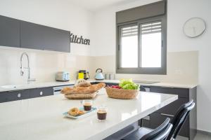 a kitchen with a table with baskets of food on it at Achziv Beach Life with Stunning Sea Views by Sea N' Rent in Nahariyya