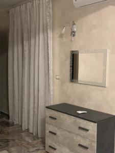 a bedroom with a dresser and a mirror on the wall at Le Stanze della Braceria Calabrese in Scilla