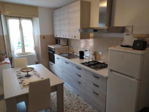 cocina con nevera blanca y fogones horno superior en Appartamento Gianna, en Porto Valtravaglia