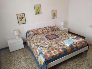 a bedroom with a bed with a colorful quilt on it at Appartamento Gianna in Porto Valtravaglia