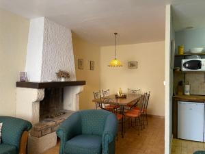 a kitchen and dining room with a table and a fireplace at Montagne d'Alaric in Moux
