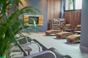 Ein Wartezimmer mit Stühlen und einem Fernseher an der Wand. in der Unterkunft 24Seven Hotel Schwabach in Schwabach
