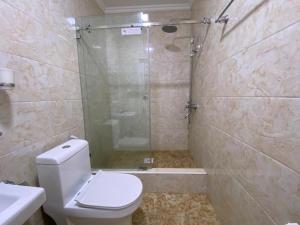 a bathroom with a shower and a toilet and a sink at Comfort Hotel in Türkistan