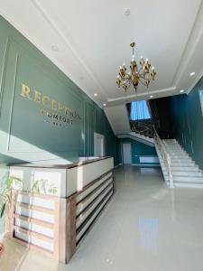 a hotel lobby with a reception counter and a chandelier at Comfort Hotel in Türkistan