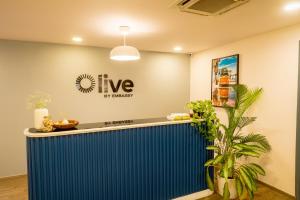 an office lobby with a blue counter and a sign that reads live hy biotech at Olive Magrath - By Embassy Group in Bangalore