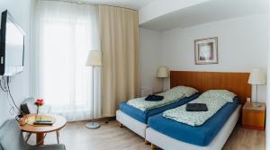 una camera d'albergo con due letti e un tavolo di Dudok House a Žilina