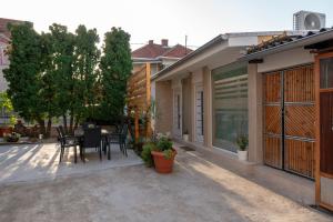 eine Terrasse eines Hauses mit einem Tisch und Stühlen in der Unterkunft Prestige Apartments in Niš