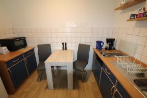 a small kitchen with a table and chairs in it at Gästewohnung "ALTE SPINNEREI" in Kirchberg