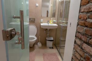 a bathroom with a toilet and a sink at Prestige Apartments in Niš +14 photos