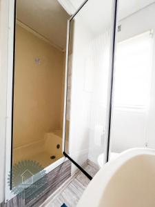 a bathroom with a tub and a glass shower door at Camping Zvejnieksēta in Pāvilosta