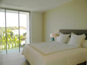 Un dormitorio con una cama grande y una ventana grande. en Limonero 17, golf club in Las Colinas, en Orihuela Costa 188 fotos más