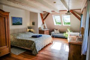Landhaus einer Malerin في Poseritz: غرفة نوم بسرير واريكة في غرفة