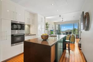 a kitchen with a large island with a bowl of fruit on it at 20 S at the Marina in Airlie Beach