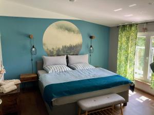 1 dormitorio azul con 1 cama con una pintura en la pared en Ferienwohnungen Zur Biberburg, en Friedrichswalde