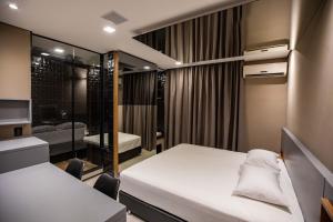 a small bedroom with two beds and a mirror at Drops Motel e Hotel Campinas in Campinas