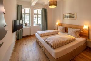 a bedroom with two beds and a flat screen tv at Haus Mittenmank am Marktplatz in Goslar