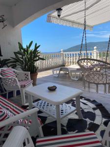 een patio met een witte tafel en stoelen op een veranda bij Guest House Cvoro in Herceg-Novi