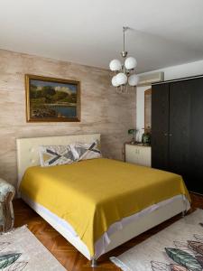 een slaapkamer met een bed met een gele deken bij Guest House Cvoro in Herceg-Novi