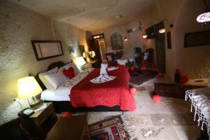 OrtahisarにあるTurkish Cave Houseのベッドルーム1室(赤毛布付きの大型ベッド1台付)
