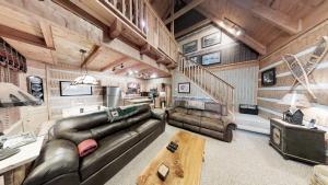 a living room with a leather couch and a staircase at Streamsong Secluded Creek View Cabin in Hatchertown