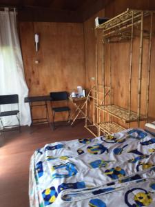 jungleadventure cabin camping في بيدوغول: غرفة نوم بسرير وطاولة وكرسي