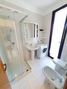 bagno con doccia, lavandino e servizi igienici di appartamento con piscina Il glicine sul garda a Desenzano del Garda