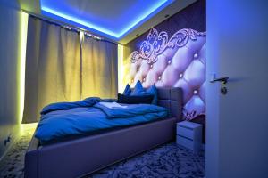 ein Schlafzimmer mit einem Bett mit einer lila Wand in der Unterkunft Little Suite in Halle an der Saale