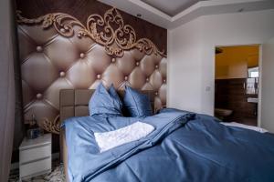 a bedroom with a blue bed with a large headboard at Little Suite in Halle an der Saale