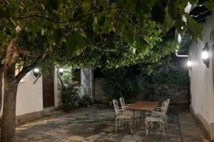 una mesa y sillas bajo un árbol en un patio en Casita El Acebo, en Cercedilla