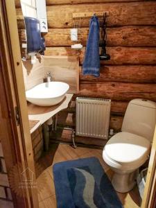 a bathroom with a white toilet and a sink at Guest house Zvejnieksēta in Pāvilosta