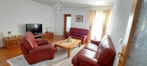 Una sala de estar con un sofá y sillas y un televisor. en MB Deluxe Apartment, en Visoko
