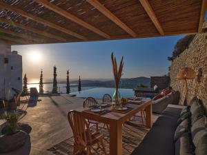 d'une terrasse avec une table et une vue sur l'eau. dans l'établissement Infinity sea view hillside villa with private pool, à Parikia