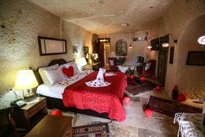 a bedroom with a large bed with a red blanket at Turkish Cave House in Ortahisar