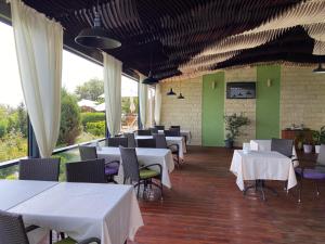 a restaurant with white tables and chairs and green walls at Villa Lavanda in Vapnyarka
