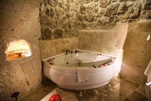 a bathroom with a bath tub and a sink at Turkish Cave House in Ortahisar