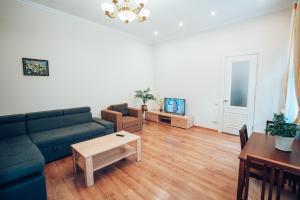 uma sala de estar com um sofá e uma mesa em Wonderful flat on city center (10) em Uzhhorod